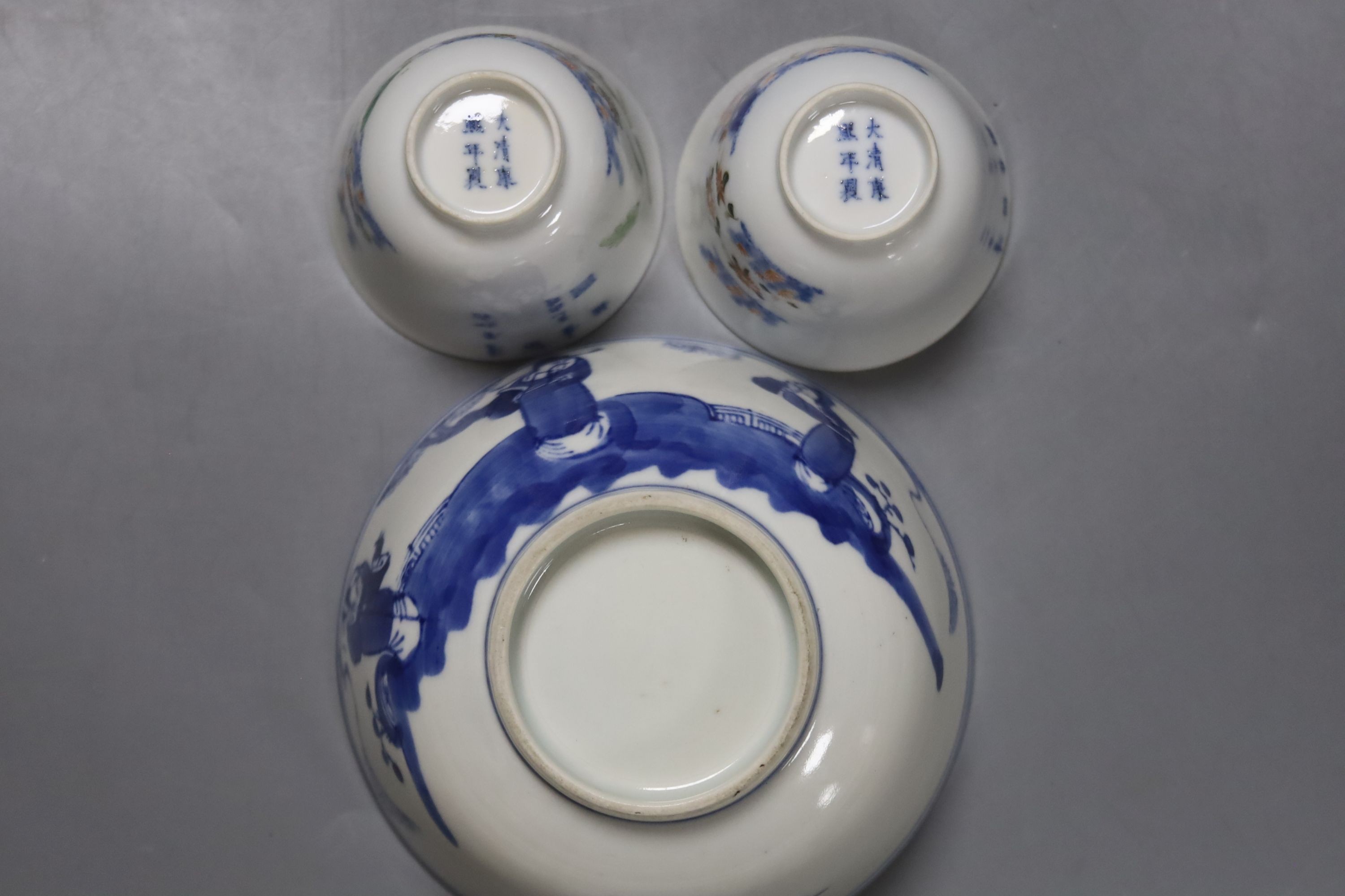 A pair of Chinese blue and white jars and covers, 6.5cm, on wood stands, a Chinese blue and white bowl and two small enamelled wine cups